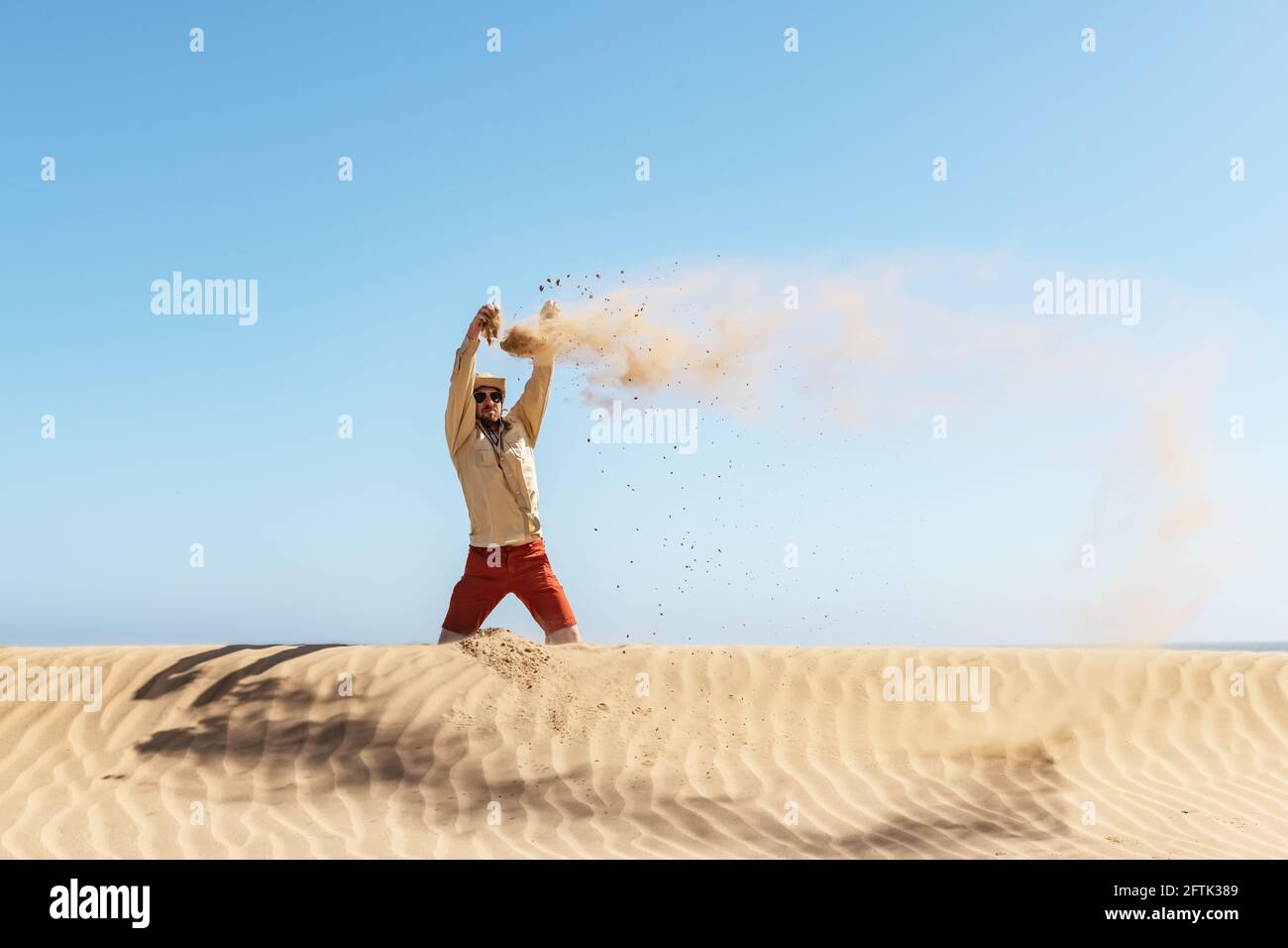 Ein einziger Mann wirft Sand in die Wüste Namib Stockfoto