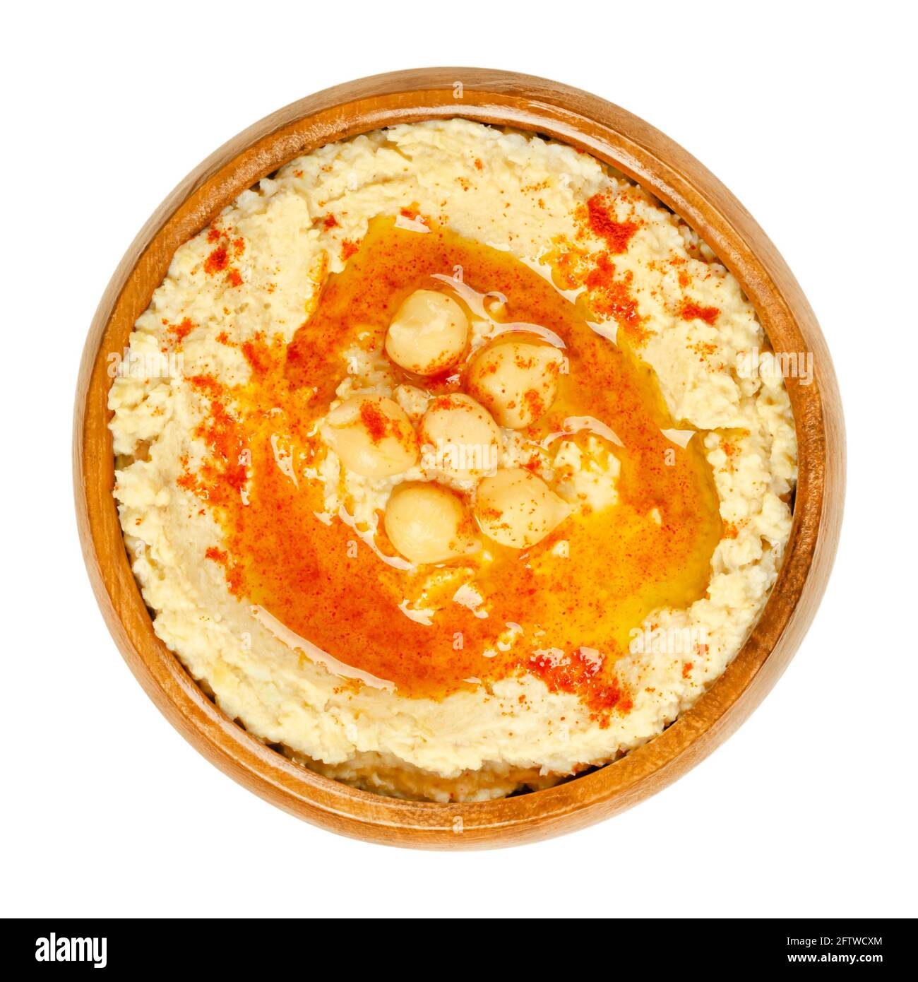 Hummus Dip mit Paprikapulver und Öl, in einer Holzschale. Nahost-Dip, Aufstrich oder herzhaftes Gericht aus gekochten, pürierten Kichererbsen. Stockfoto