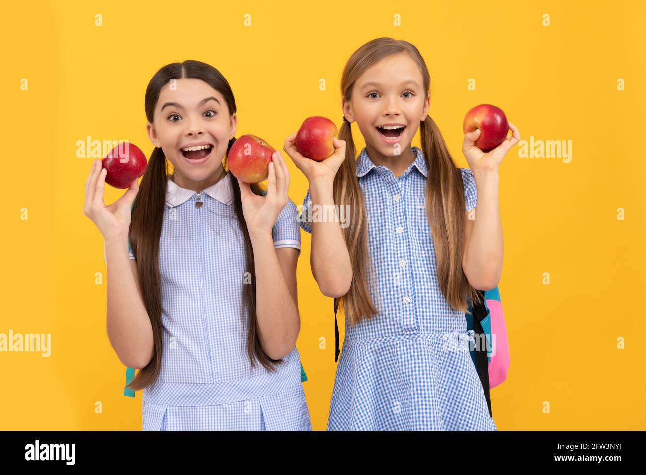 Essen Sie Obst, um süß zu sein. Glückliche Schulfreunde halten Äpfel. Gesunde Ernährung. Immer richtig essen Stockfoto