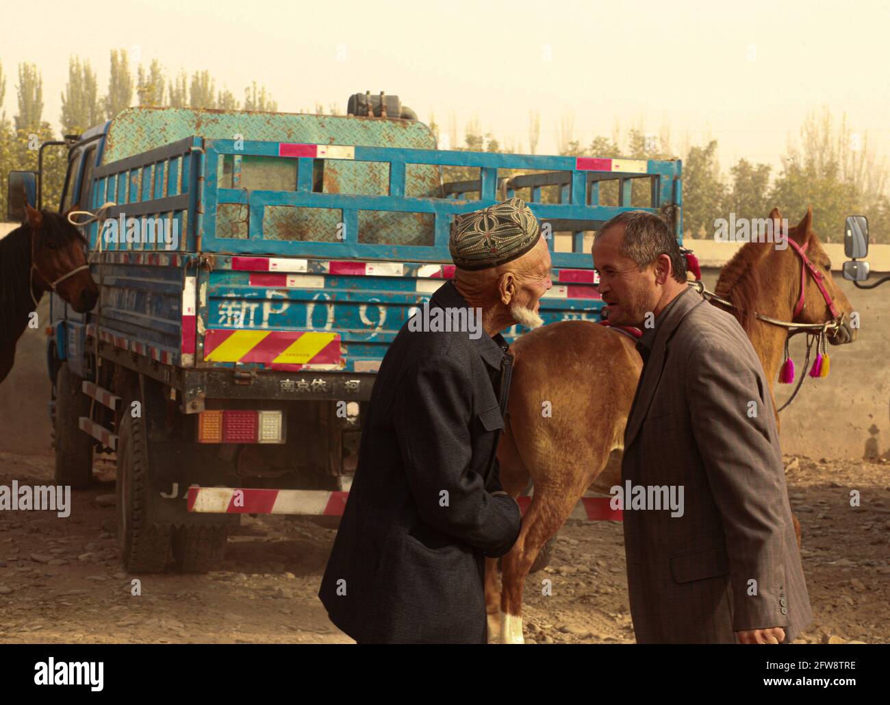 Zwei Mann auf der Tiermesse Kashgar, Sinkiang, Volksrepublik China, 2019 Stockfoto