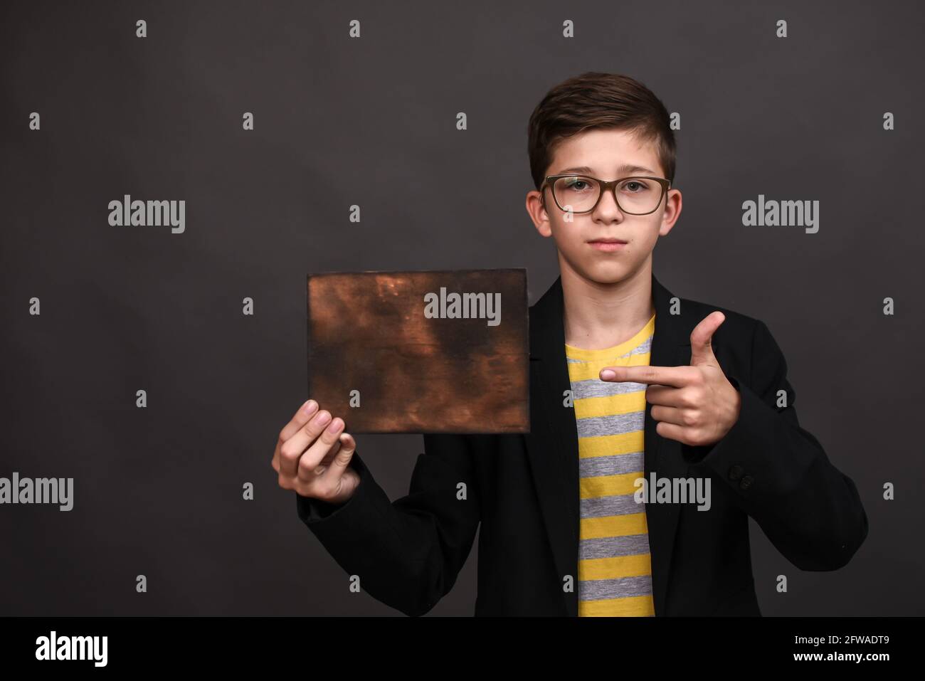 Der Junge zeigt auf ein leeres Holzbrett Stockfoto