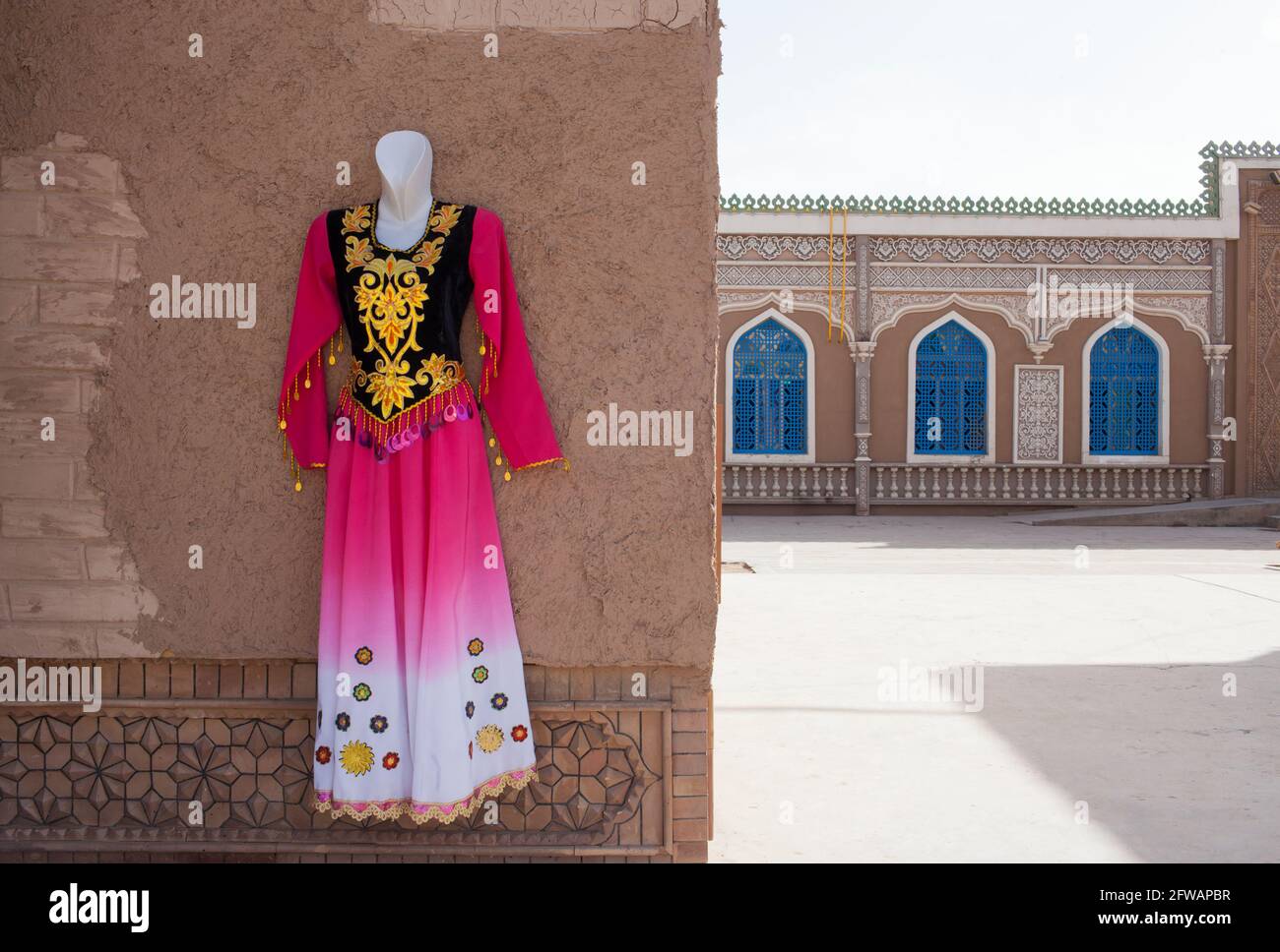 Ein traditionelles und festliches Kleid, das an einer Wand hängt Kashgar, Xinkiang, Volksrepublik China, 2019 Stockfoto