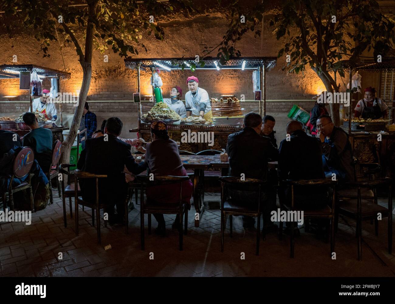 Menschen sitzen im Straßenrestaurant Kashgar, Sinkiang, Volksrepublik China, 2019 Stockfoto