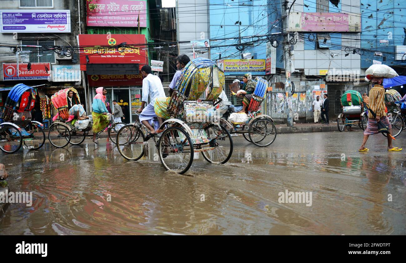Fahren Sie mit Rikschas durch überflutete Straßen in Dhaka, Bangladesch. Stockfoto