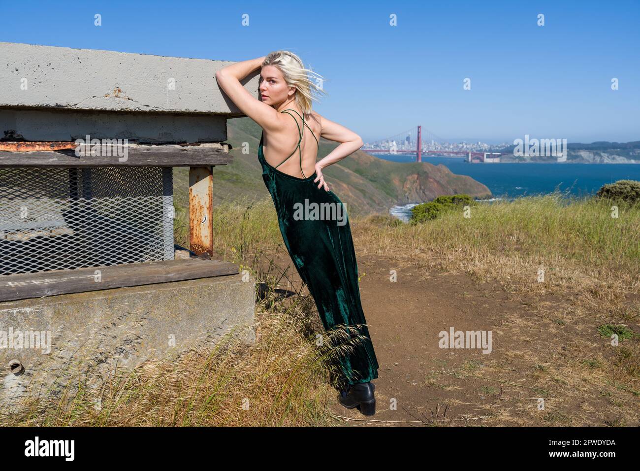 Mode an ungewöhnlichen Orten, Junge Frau klettert Betonpistole Batterieruinen Stockfoto