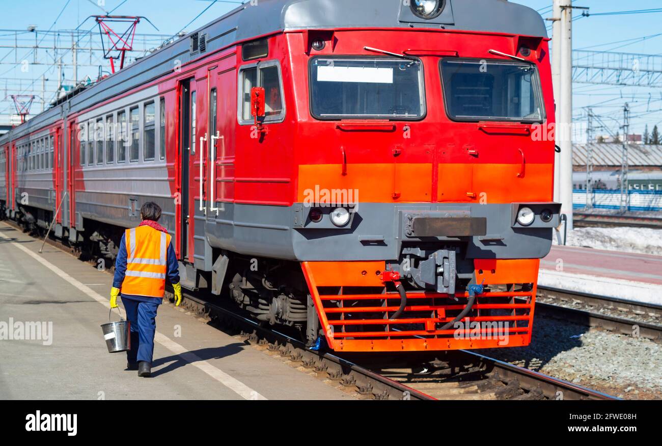 Die Lokomotive wird vor der Abreise bedient, eine Frau in einer orangefarbenen Weste, Nahaufnahme Stockfoto