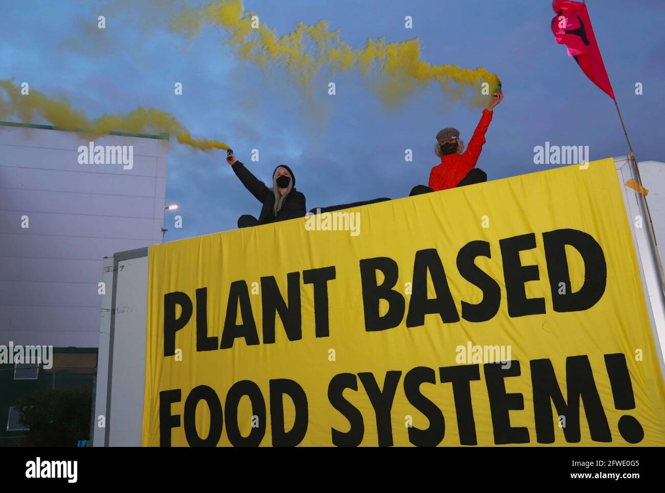 Coventry, Großbritannien, 22. Mai 2021 Animal Rebellion blockiert McDonalds Vertriebszentren in ganz Großbritannien. In den frühen Morgenstunden wurden alle vier Vertriebszentren, die 1300 Fast-Food-Filialen beliefern, von mehr als 50 Demonstranten in einer koordinierten Aktion gegen die Tierlandwirtschaft ins Visier genommen. In Coventry wurden zwei riesige Bambusstrukturen mit Bergsteigern vor Ort und Protestierenden an Betonbasen errichtet. Kredit: Denise Laura Baker/Alamy Live Nachrichten Stockfoto