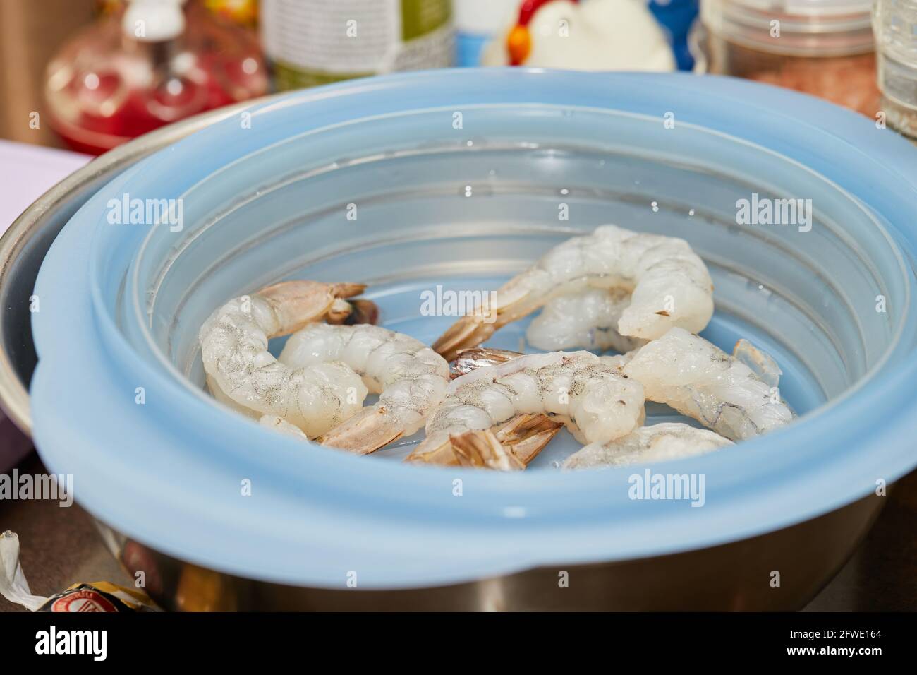 Frische Garnelen in Plastikschüssel, fertig zum Kochen. Stockfoto