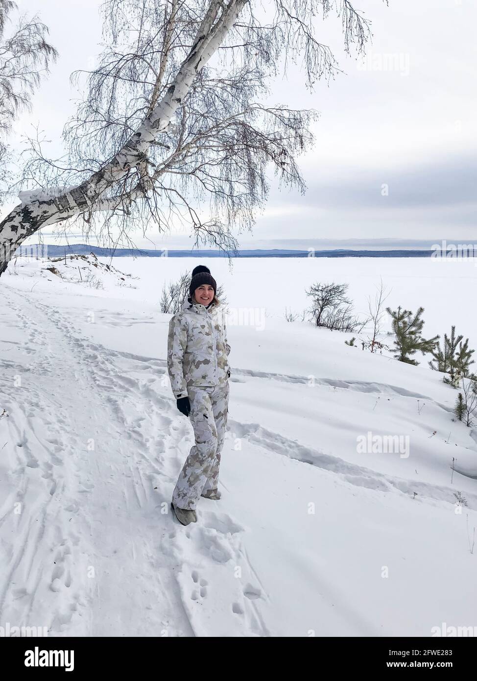 Junge lächelnde Frau genießt verschneiten Wintertag. Stockfoto