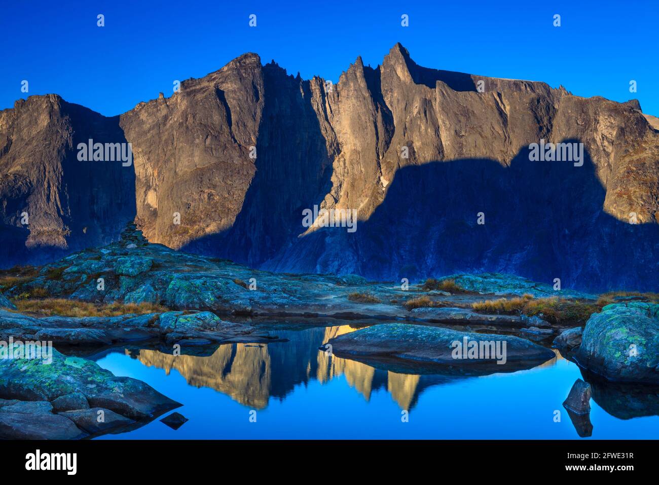 Frühmorgendliches Licht auf der 1000 Meter hohen Trollveggen-Mauer und den Gipfeln Trolltinden im Romsdalen-Tal, Møre Og Romsdal, Norwegen. Stockfoto