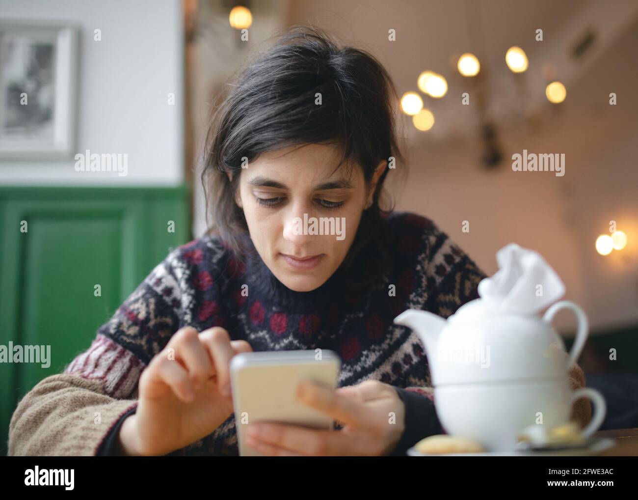 Junge Frau, die im Café telefoniert. Stockfoto