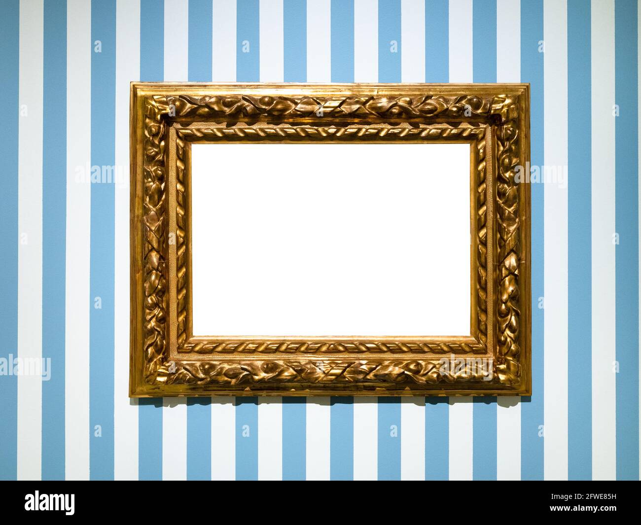 Breiter barocker Bilderrahmen aus Holz mit ausgeschnittem Canvas auf Blau Gestreifte Wand Stockfoto