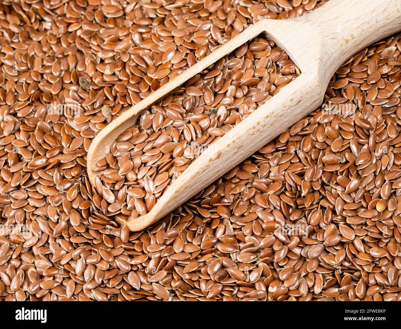 Holzlöffel in braunen Leinsamen aus nächster Nähe Stockfoto