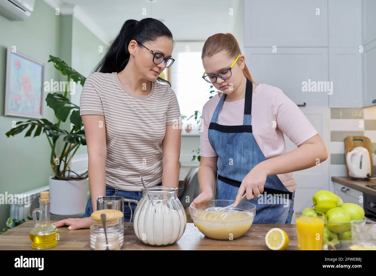 Mutter und Tochter 12, 13 Jahre alt kochen gemeinsam Apfelkuchen Stockfoto