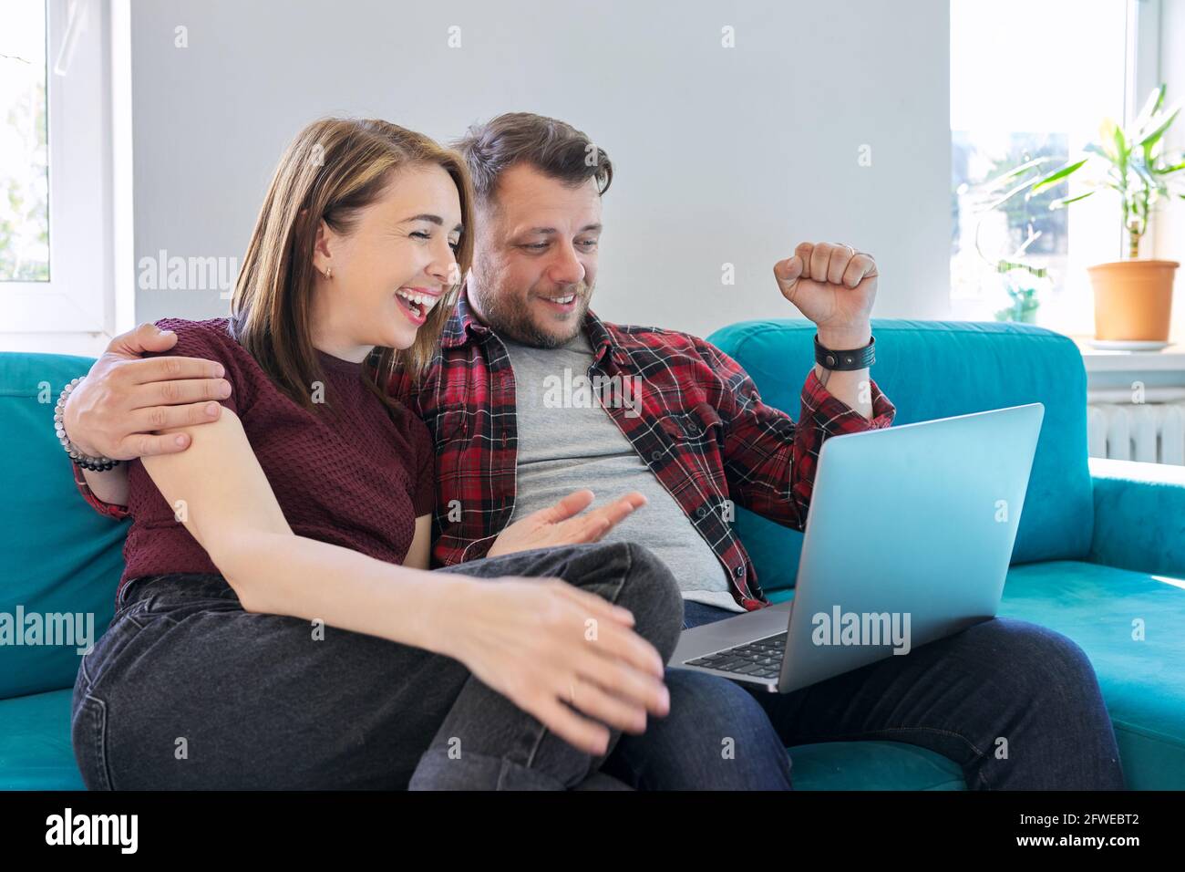 Glück, Glück, Freude, Sieg, gewonnen, Glückliches, emotionales Paar mittleren Alters, das in einem Laptop schaut Stockfoto