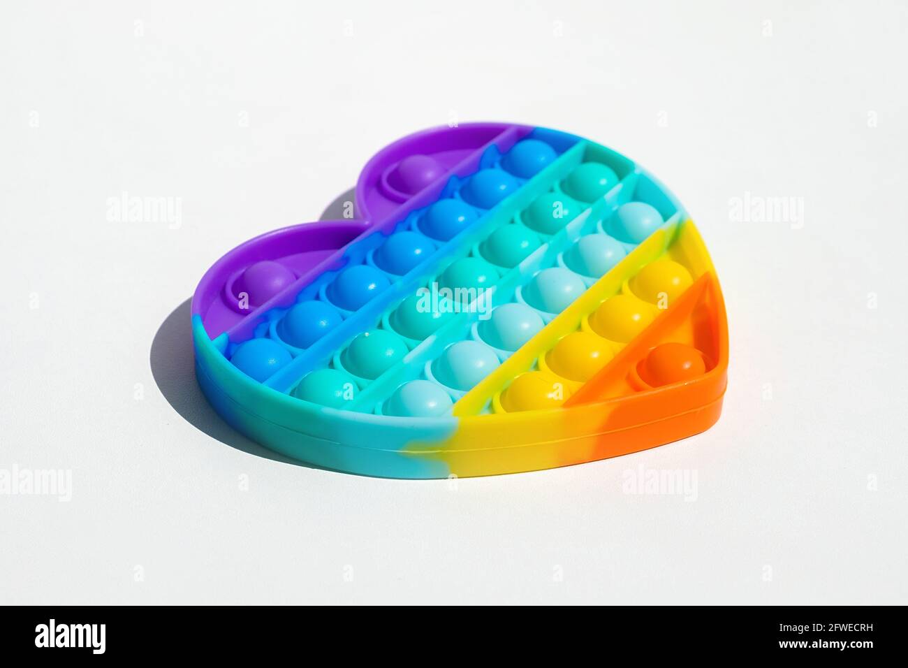 Antistress-Pop-it-Spielzeug. Regenbogen sensorische Fidget isoliert auf weißem Hintergrund. Neues trendiges Silikon-Spielzeug. Stockfoto