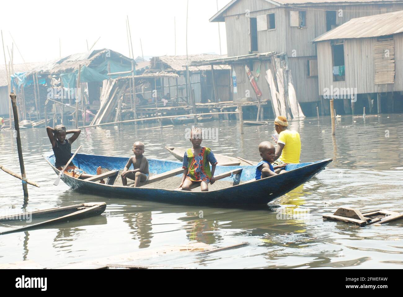 Ein Junge, der im Makoko Slum, Lagos, Nigeria, ein Kanu paddelt. Stockfoto