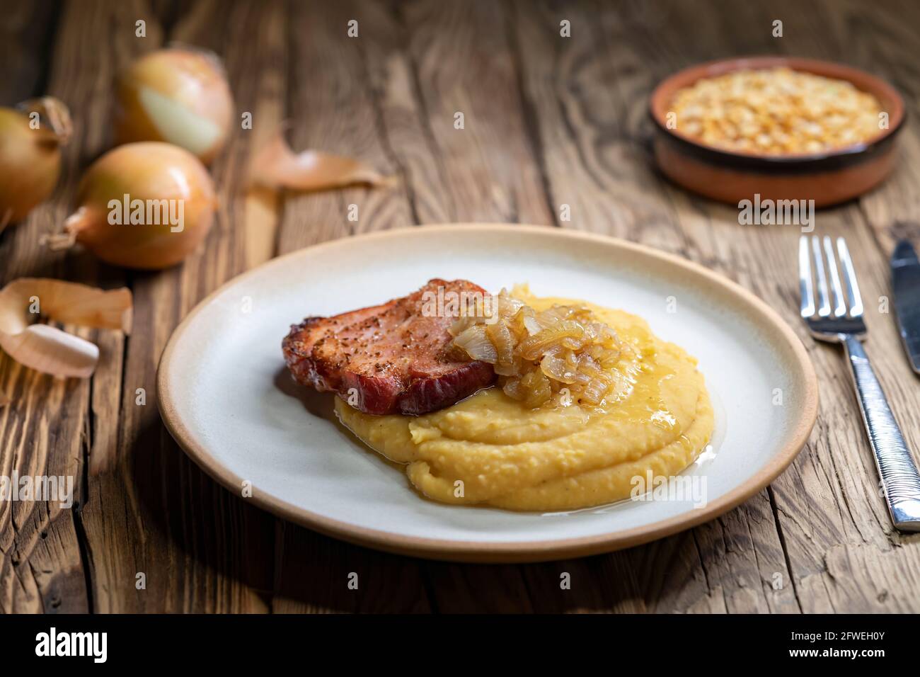 Tschechische Küche, geräuchertes Fleisch mit Erbsenbrei und gebratene Zwiebel bis golden Stockfoto