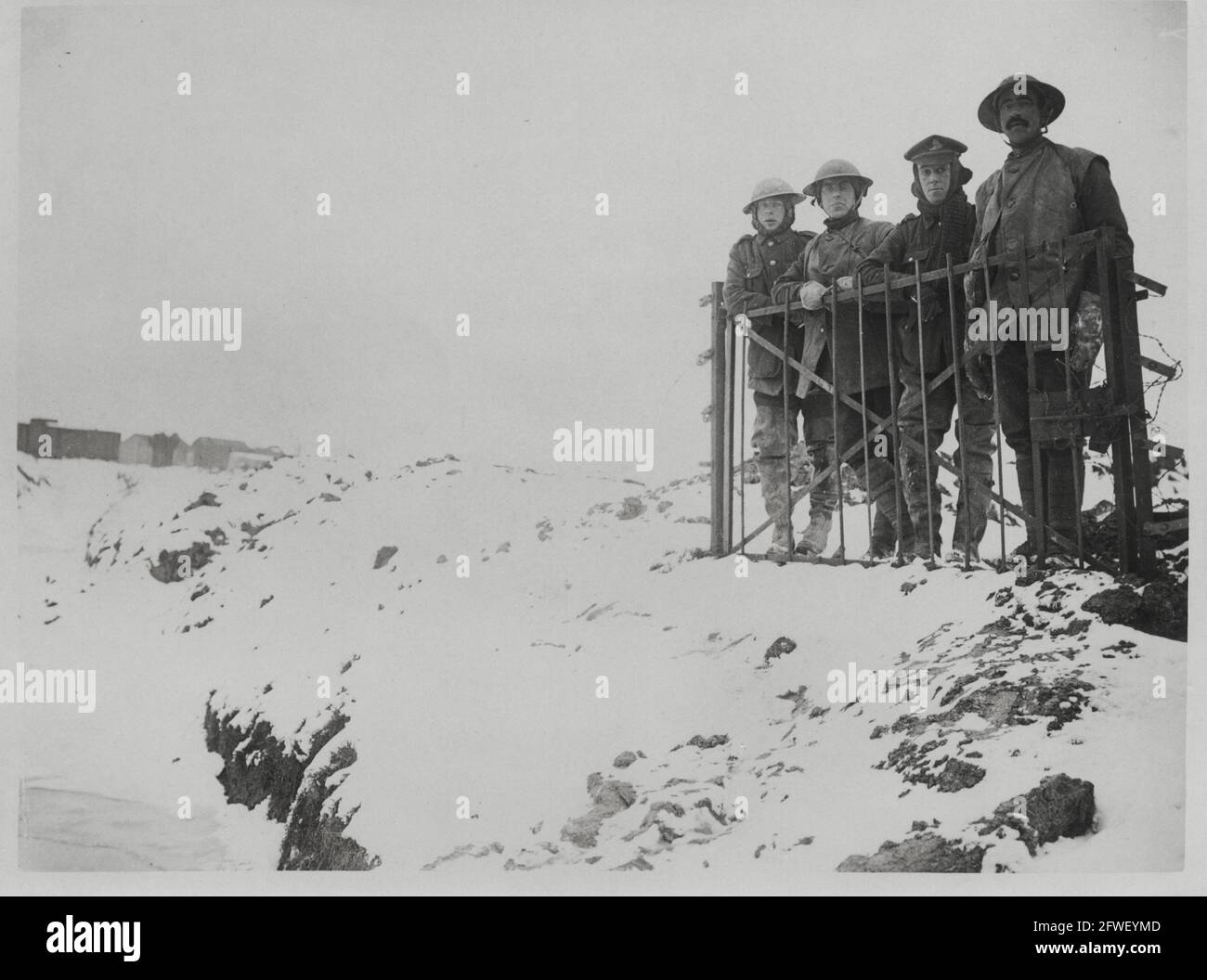 Erster Weltkrieg, erster Weltkrieg, Westfront - vier Männer lehnen sich an einem freistehenden Tor im Schnee an der Front, Frankreich Stockfoto