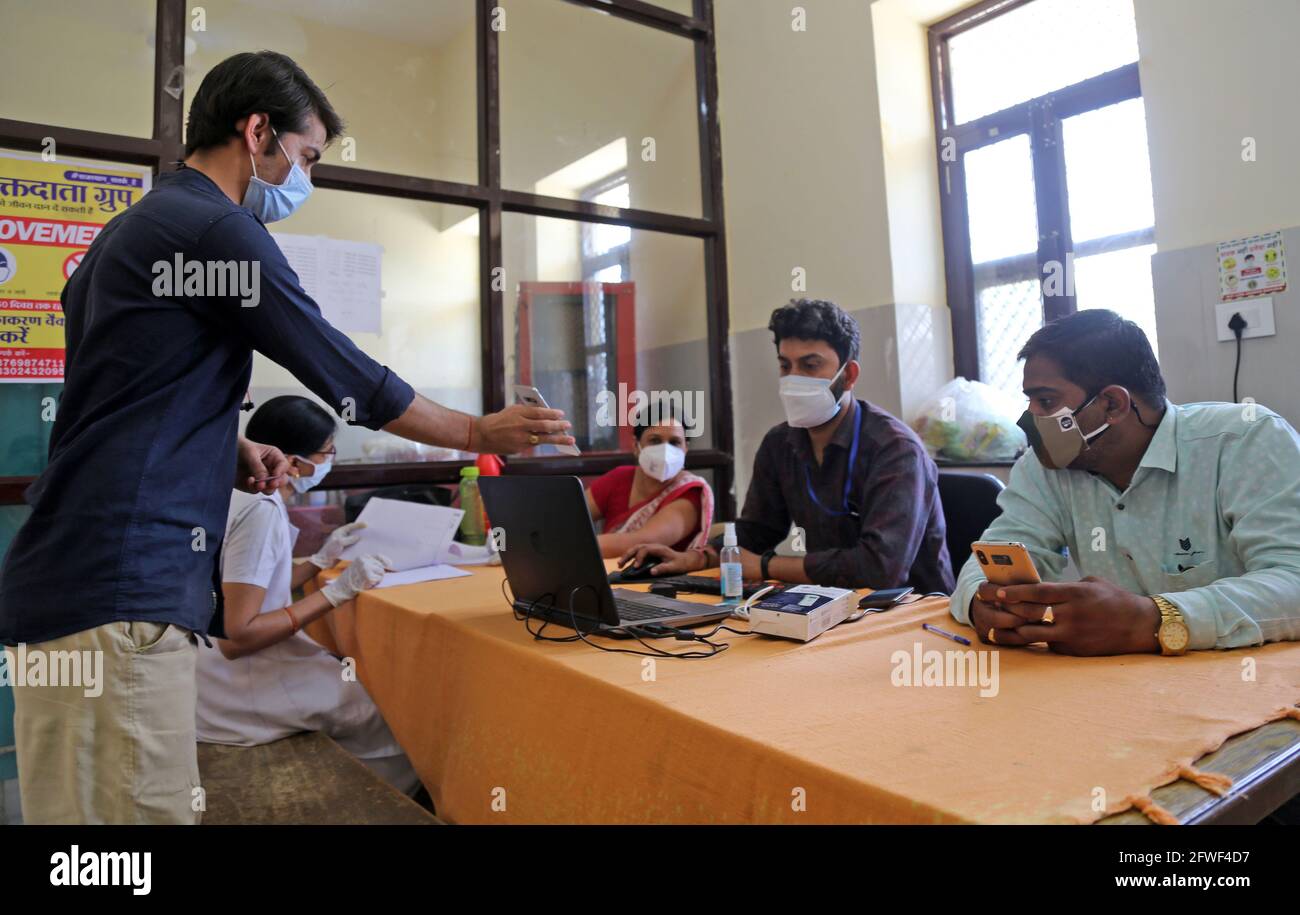 Beawar, Rajasthan, Indien, 22. Mai 2021: Die Gesundheitshelferin Abhijeet Sharma und Teena Rajawat nehmen während der Impfkampagne gegen COVID-19 in einem Impfzentrum in Beawar die persönlichen Angaben eines Hausbewohners für Corona-Impfstoff an einem Registrierschalter mit. Kredit: Sumit-Samarwat/Alamy Live Nachrichten Stockfoto