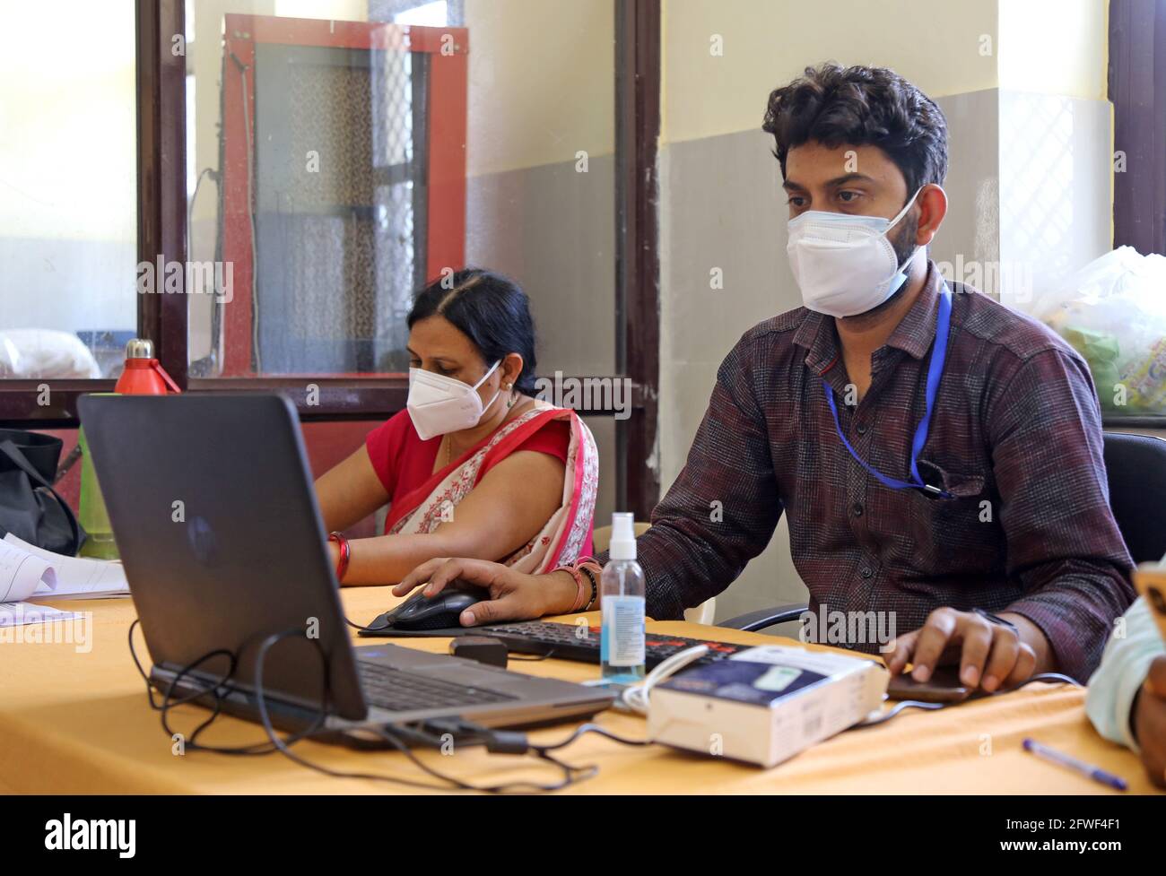 Beawar, Rajasthan, Indien, 22. Mai 2021: Die Gesundheitshelferin Abhijeet Sharma und Teena Rajawat nehmen während der Impfkampagne gegen COVID-19 in einem Impfzentrum in Beawar die persönlichen Angaben eines Hausbewohners für Corona-Impfstoff an einem Registrierschalter mit. Kredit: Sumit-Samarwat/Alamy Live Nachrichten Stockfoto