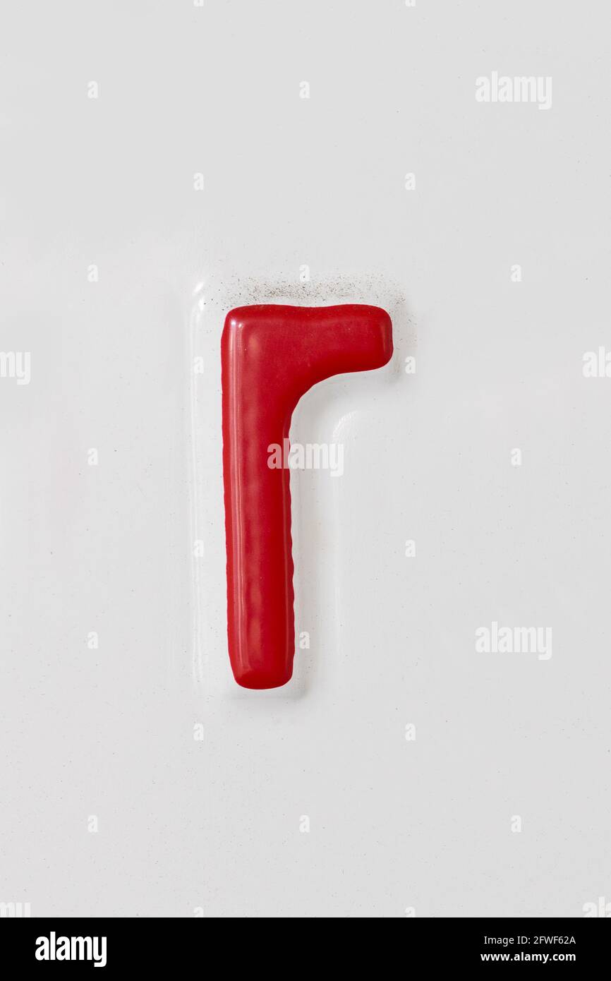 Geprägter roter Buchstabe r auf einem weißen Blechteller Stockfoto