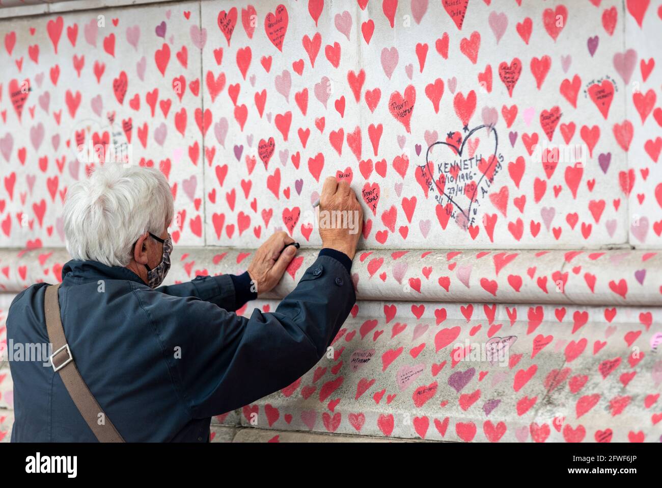 Westminster, London, Großbritannien. Mai 2021. An einem langweiligen Tag in London wird die National Covid Memorial Wall gegenüber dem Palace of Westminster mit einem weiteren Namen versehen, der ein verlorenes Leben bezeichnet Stockfoto