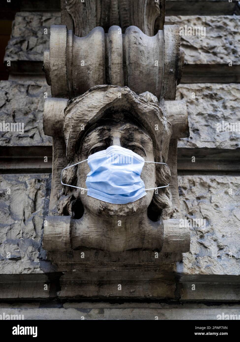 Relief an einer Hausfront mit Gesichtsmaske während der Covid-19 Pandemie. Mannheim, Mai 2021 Stockfoto