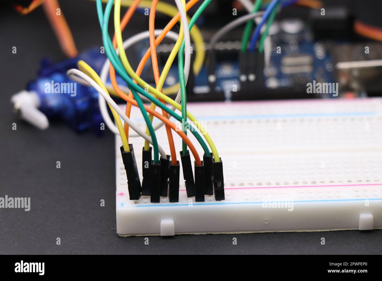 Science-Projekte oder Elektronik-Projektkonzept durch den Anschluss Jumper gezeigt Drähte zur Steckplatine mit einigen elektronischen Komponenten im Hintergrund Stockfoto