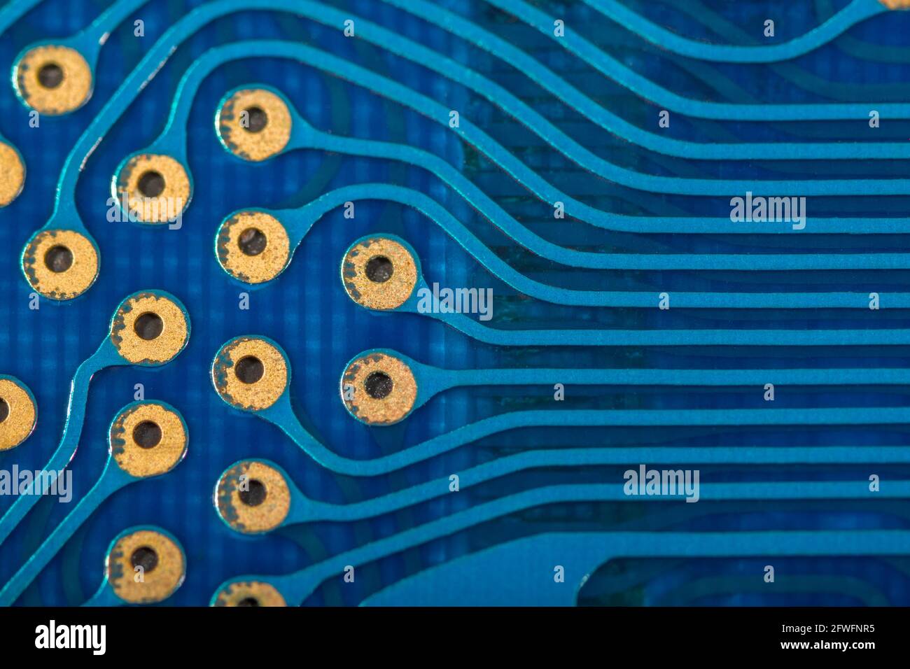 Abstraktes Makrofoto von Steckverbinderspuren und auf blauer Leiterplatte (pcb) von einem alten Canon Taschenrechner im Kreditkartenformat. Für Elektronikdesign Stockfoto
