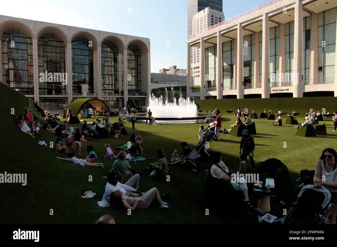 Mai 2021. New York City, USA. Menschen, die den 14.000 Quadratmeter großen Teppich aus Kunstrasen genießen, der auf dem Josie Robertson Plaza im New Yorker Lincoln Center eingerichtet wurde. Der Rasen, der von dem renommierten Bühnenbildner Mimi Lien entworfen wurde, besteht aus recycelbarem, biobasierten SYNLawn, das im Rahmen des Programms „Restart Stages“ für Aufführungen des Lincoln Center verwendet wird, um die Verbindung zur Kunst zu restimulieren, während die Stadt aus der Pandemie herauskommt. Quelle: Adam Stoltman/Alamy Live News Stockfoto