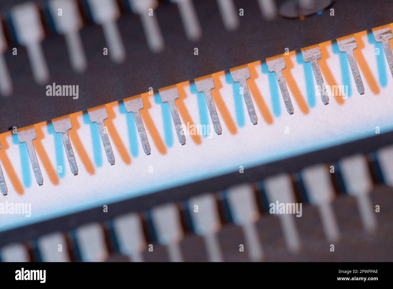 Makroaufnahme der Stiftschaltungen des Halbleiters PIC16F77-I/P von Microchip Technology. Für Elektronik abstrakt, Industriekomponenten abstrakt. Stockfoto