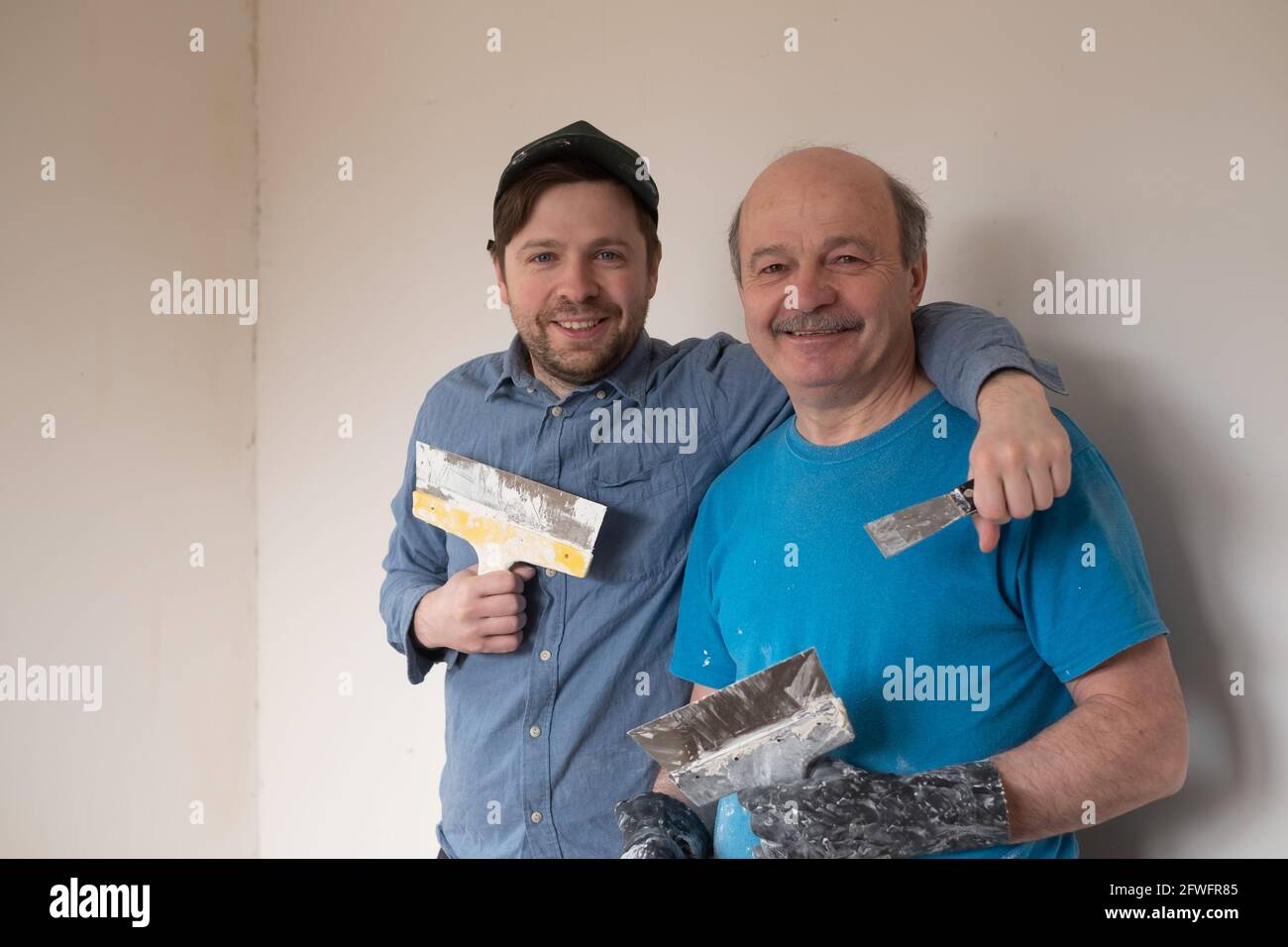 Reife Handwerker mit Kitt Messer lächelnd Blick auf die Kamera Stockfoto