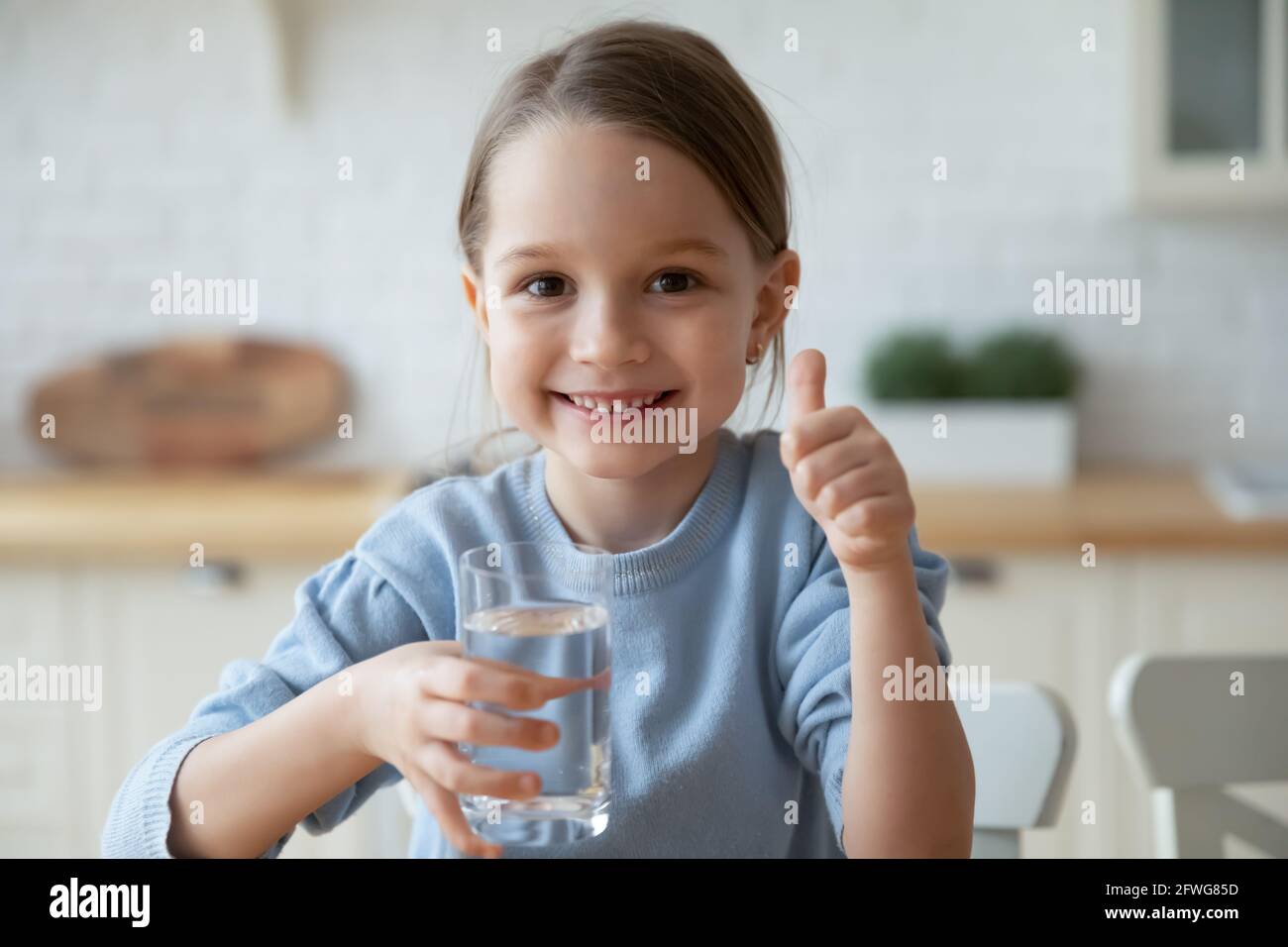 Porträt des lächelnden kaukasischen Mädchen Kind trinken Mineralwasser Stockfoto