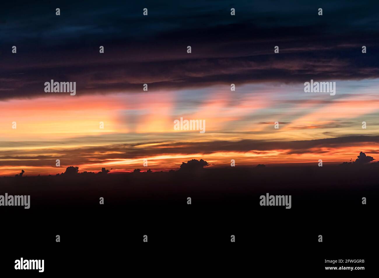 Dunkle Wolken und Sonnenaufgang über Wolken Stockfoto