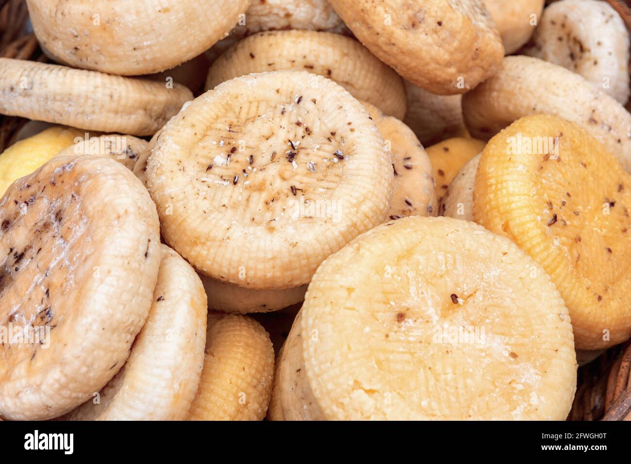 Runder geräucherter Käse im Korb auf dem Markt. Stockfoto