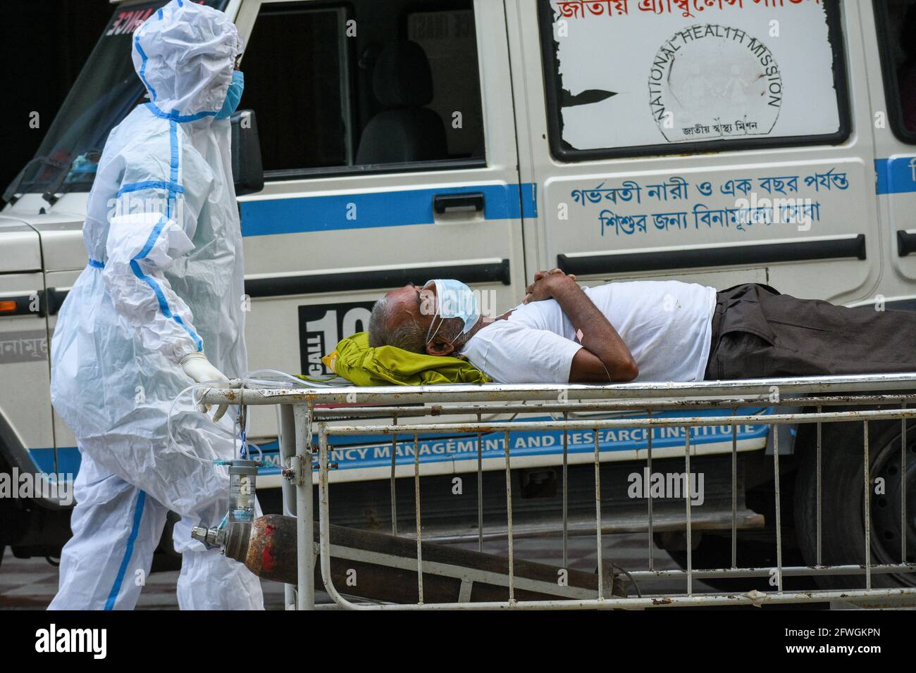 Ein Mann, der positiv auf COVID-19 getestet wurde, wird von einem medizinischen Mitarbeiter in einem Krankenhaus auf eine Intensivstation gebracht. Kalkutta, Indien. Stockfoto