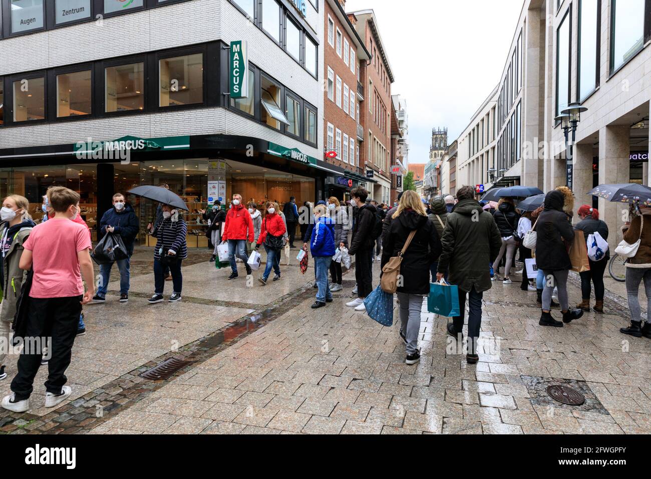 Münster, NRW, Deutschland. Mai 2021. In der Altstadt von Münster versammeln sich trotz heftigem Regen Menschenmassen, denn es wird die erste Stadt in Nordrhein-Westfalen, in der es möglich ist, Indoor-Trink- und Gastronomiebereiche (mit negativem Test oder Impfung) und Shopping ohne Test oder Termin (aber die Anzahl ist begrenzt) zu eröffnen. Münster hat derzeit mit 17/100k eine der niedrigsten covid-Inzidenzraten in NRW und hat sich zu einer „Modellregion“ entwickelt, um eine langsame Wiedereröffnung von Hospitality-Locations zu testen. Kredit: Imageplotter/Alamy Live Nachrichten Stockfoto