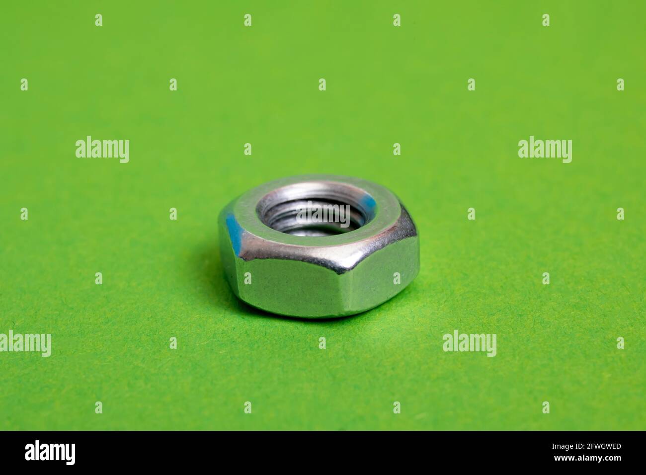 Metallmutter auf grünem Hintergrund Nahaufnahme Stockfoto