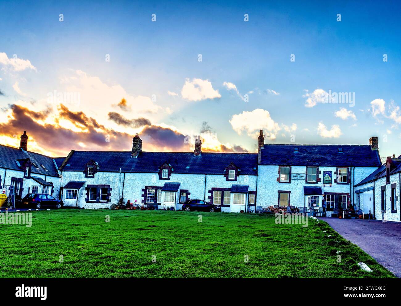 Ein Häuserblock umgibt das Dorfgrün in Low Newton, Northumberland. Stockfoto