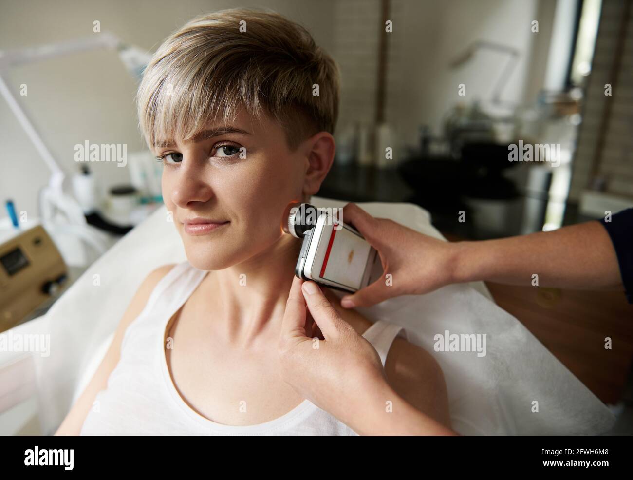 Arzt Onkologe Dermatologe untersucht die weibliche Patientin mit einem Dermatoskop zum Nachweis von bösartigen Formationen auf der Haut. Arzt Examinin Stockfoto