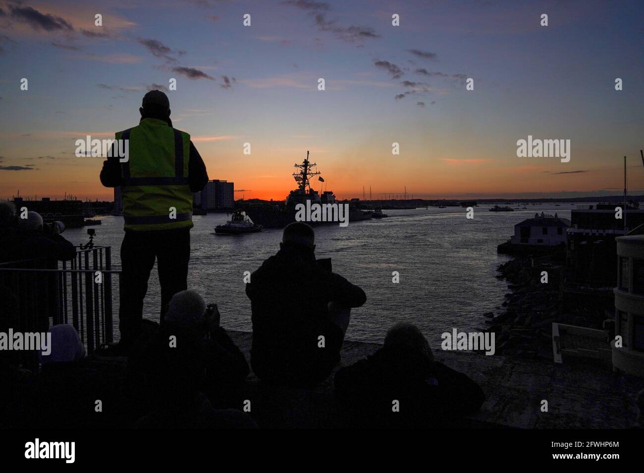 Die Menschen beobachten, wie USS the Sullivans (DDG-68), ein von Arleigh Burke geführter Raketenzerstörer der Aegis-Klasse (Flug I), vor dem Verlassen der HMS Queen Elizabeth den Marinestützpunkt HM, Portsmouth, verlässt, Der erste Einsatz des Carriers, der die britische Carrier Strike Group bei einem 28-wöchigen Einsatzeinsatz führen soll, der über 26,000 Seemeilen vom Mittelmeer bis zur philippinischen See führt. Bilddatum: Samstag, 22. Mai 2021. Stockfoto