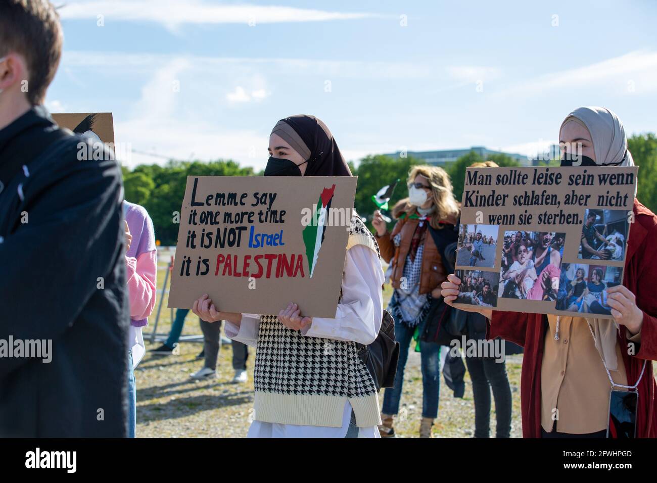 Activistinnen halten Schilder mit der Aufschrift: „ man sollte leise sein, wenn Kinder schlafen, aber nicht, wenn sie sterben. ' & ' Lasst es mich nochmal sagen Es ist nicht Israel Es ist Palästina '. Ca. 200-300 Menschen sammeln sich am 22.5.2021 in München, um ihre Solidarität mit den Menschen in Gaza, Ost Jerusalem, den besetzten Gebieten und dem Westjordanland zu zeigen. - Aktivisten halten Schilder mit der Aufschrift: "Sie sollten ruhig sein, wenn Kinder schlafen, nicht wenn sie sterben. ' & ' Lemme sagen es noch einmal, es ist NICHT Israel, es ist Palästina '. Rund 200-300 Menschen versammelten sich am 22. Mai 2021 in Muni Stockfoto