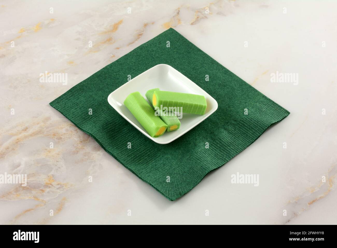 Melone und Limette Kaubonbons in weißer Süßigkeitenschale Auf grüner Papierserviette Stockfoto
