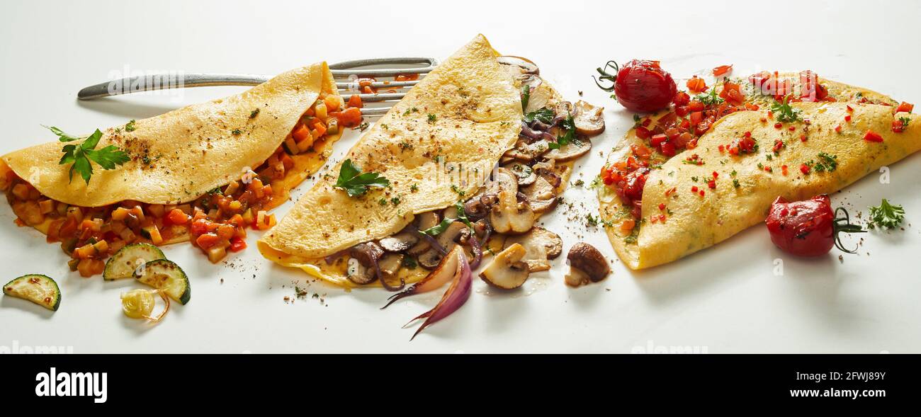 Große Auswahl an appetitlichen vegetarischen Omelettes in Reihe gestellt Auf weißem Hintergrund Stockfoto