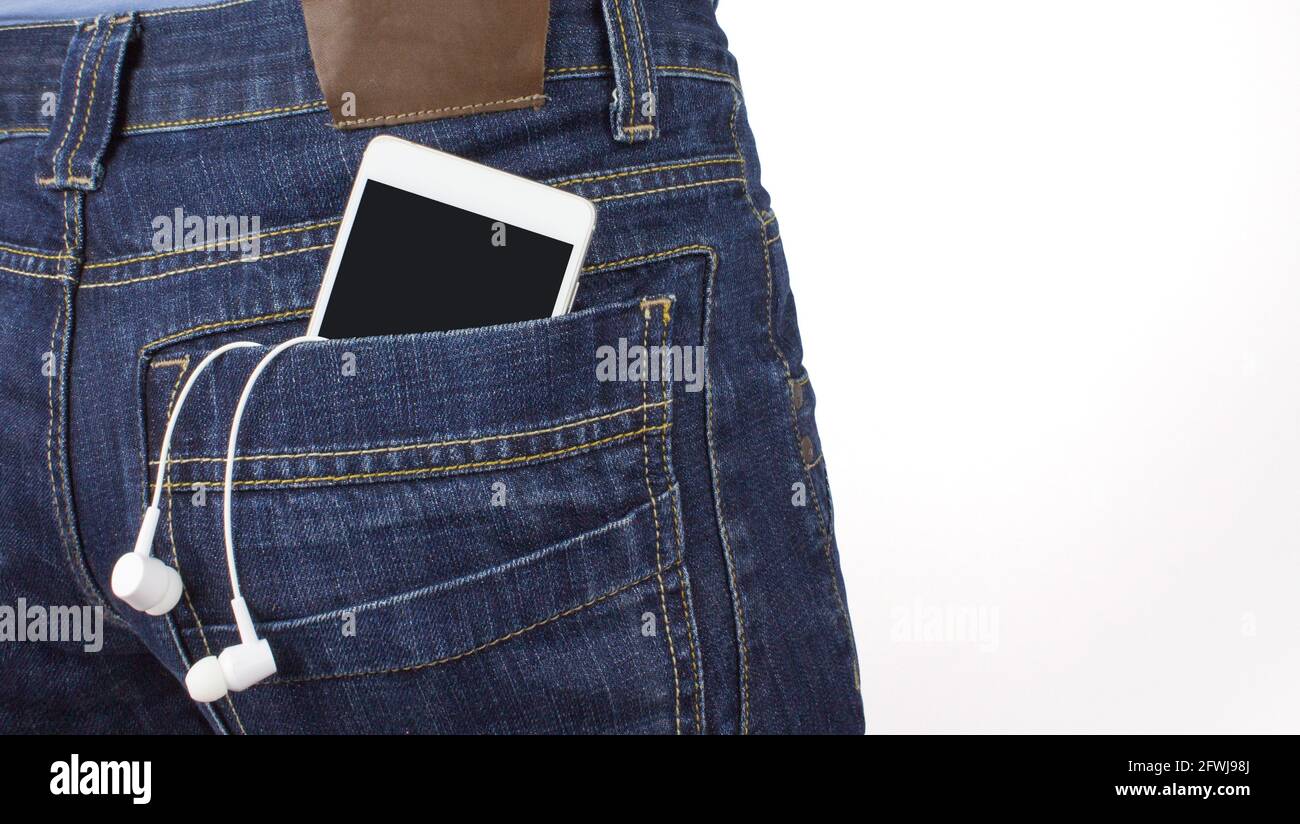 Smartphone mit transparentem Bildschirm in der Jeans-Tasche in der Nähe von Kopfhörern. Musikkonzept Stockfoto