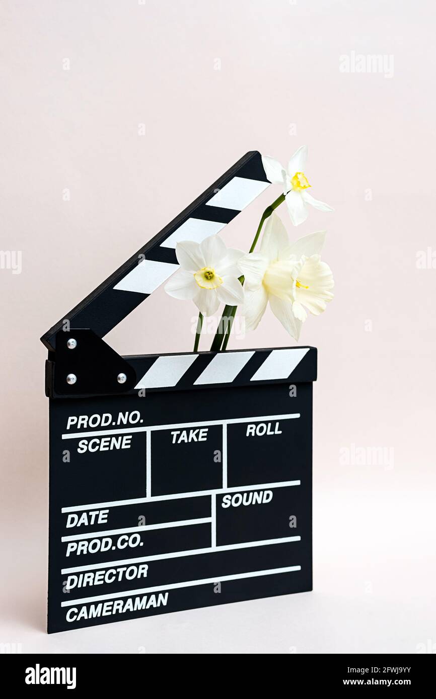 Klappbrett aus Film mit Frühlingsblumen. Minimale Standzeit der Klapptafel für die Herstellung von Video-Kino und Narzissen Blumen. Stockfoto