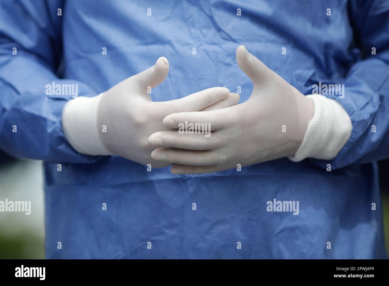 Details mit den Händen eines Arztes in Operationshandschuhen gestikulierend während des Sprechens. Stockfoto