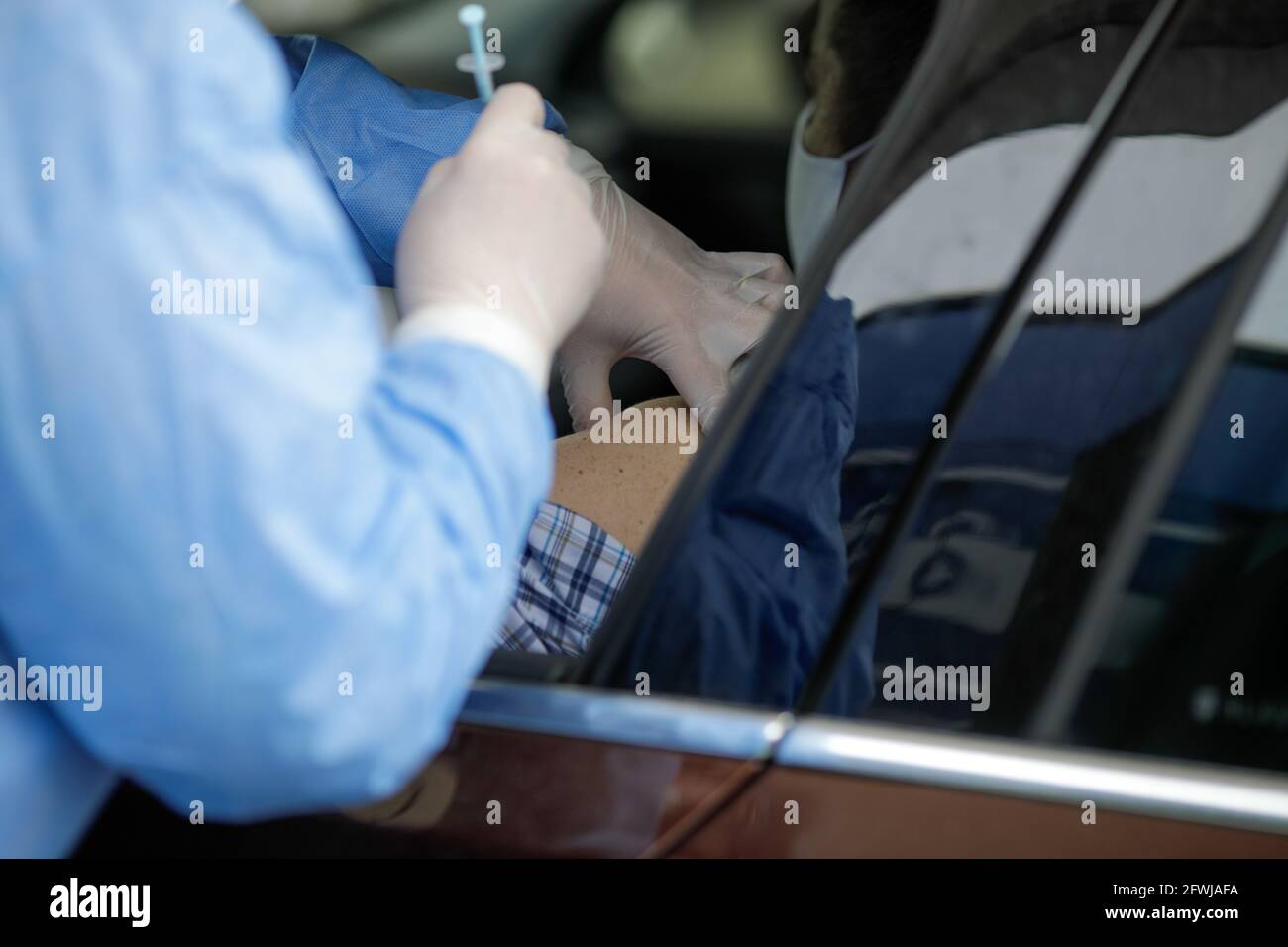 Details mit Menschen, die Covid-19-Impfstoffe direkt in ihren Autos in einem Drive-Thru-Impfzentrum in Bukarest, Rumänien, in die Arme bekommen. Stockfoto