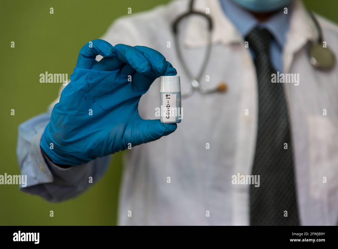 Covid 19 Probe-Impfstoffflasche, die von einer Hand gehalten wird Ein Arzt Stockfoto